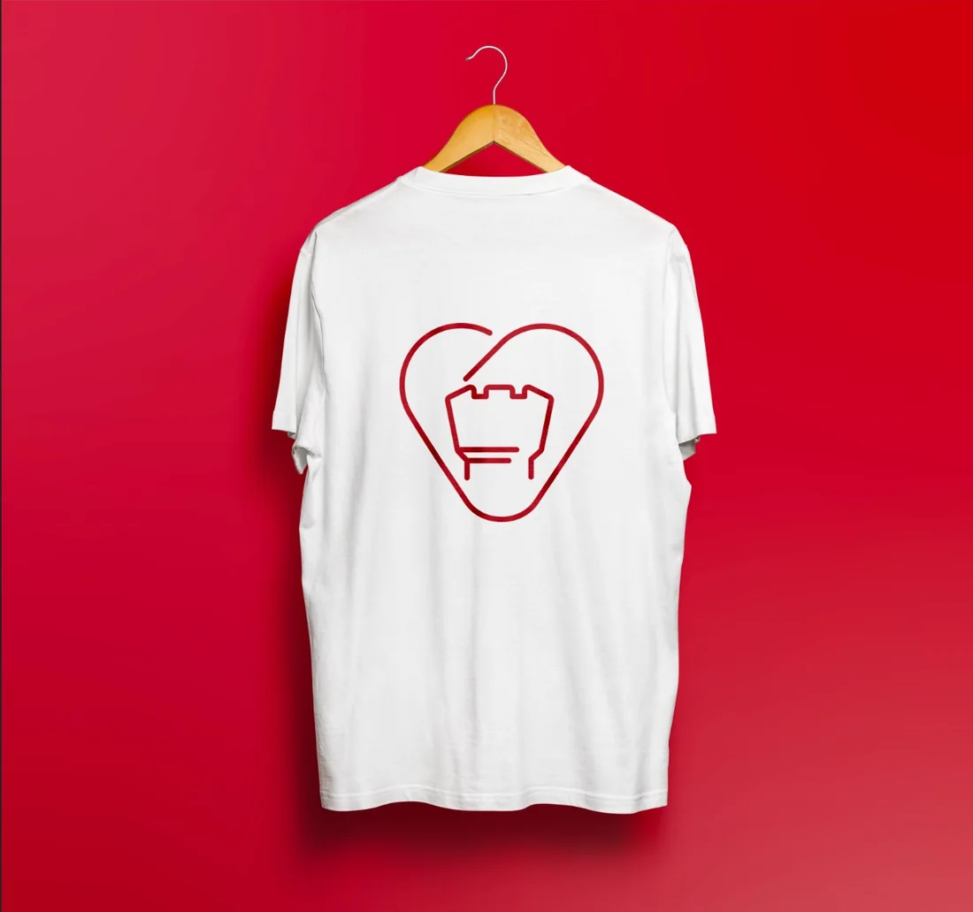 A white T-shirt on a hanger against a red ground, the mark in red across the back