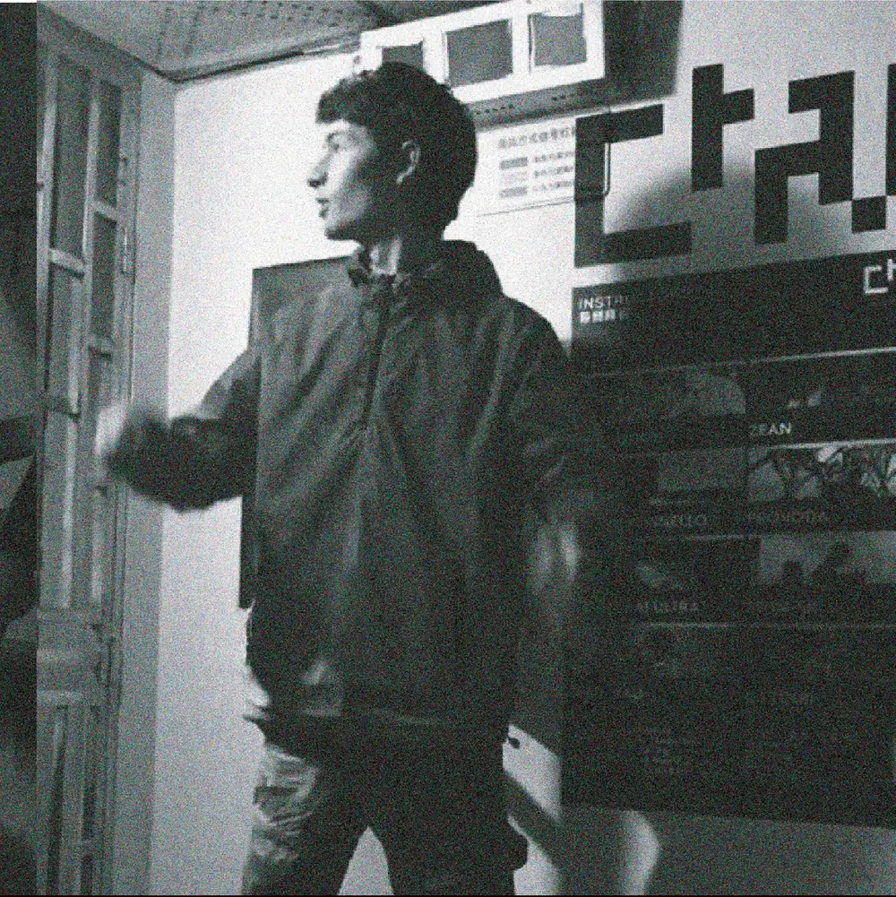 A man at the studio entrance, the logo painted on the wall behind him.