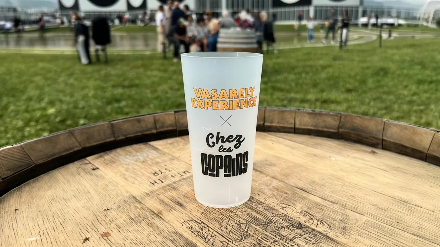 A reusable cup printed with the wordmark, photographed on site on the day.